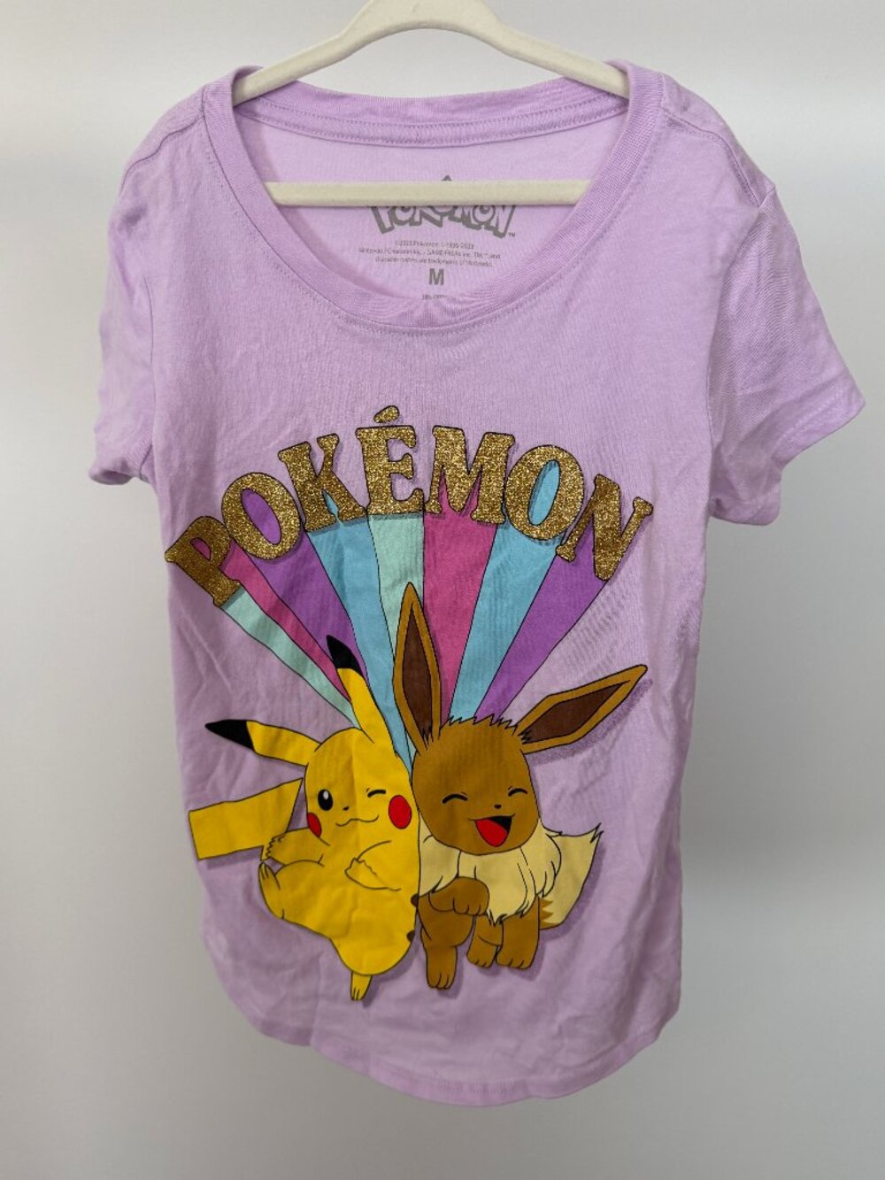 Pokemon.  Sparkly and colourful. Girls t-shirt, size Medium.  Pink/Violet tinged